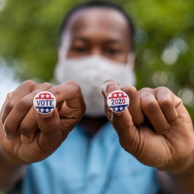 Male voter holding voting pins right after voting.